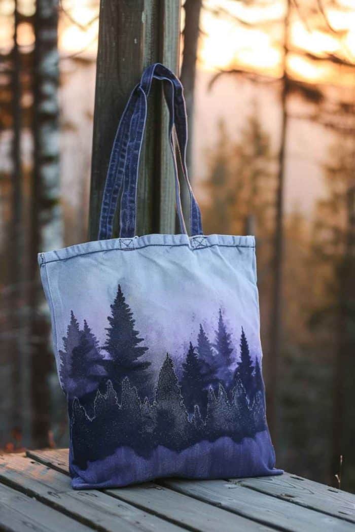 On this tote, the stark beauty of a forest silhouette is depicted against the soft, fading colors of a dusk sky.
