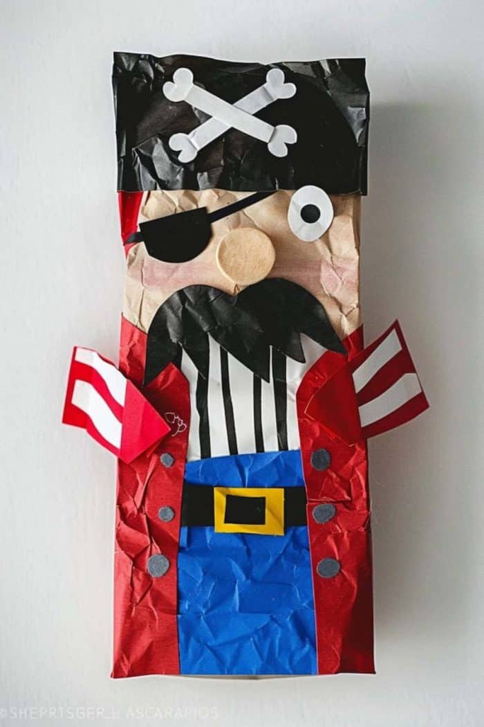 Here's a jolly pirate with a rugged eye patch and a black paper hat emblazoned with bones. His black beard makes him look adventurous!
