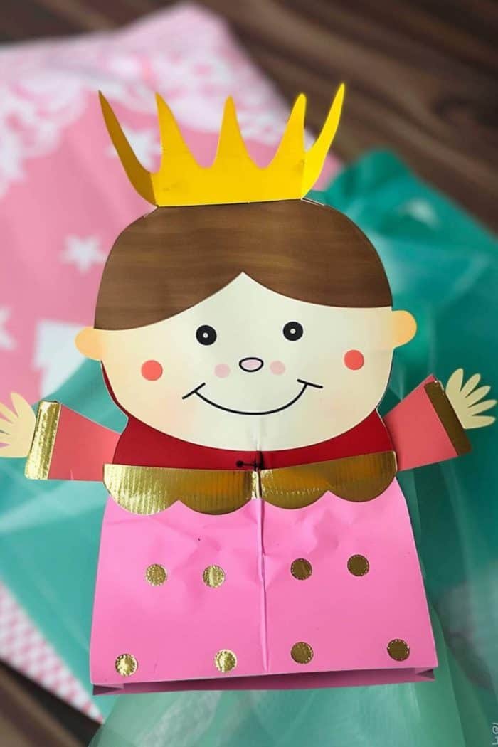 To make this elegant princess character, children can use a green paper bag for her gown, purple construction paper for her cape, and yellow paper for the crown atop her head.