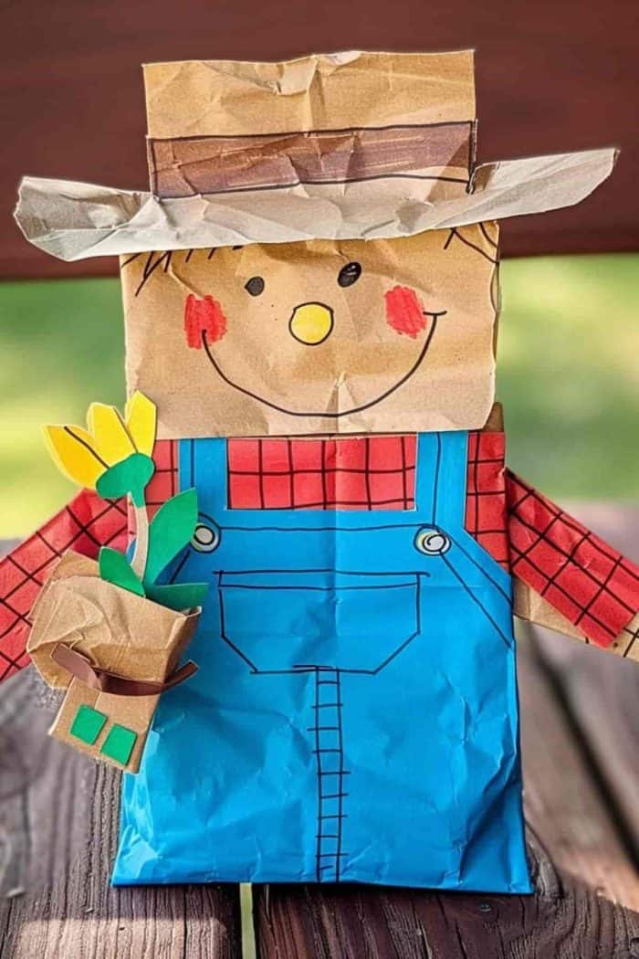 This joyful farmer beams from beneath his wide-brimmed hat, showing off his joy in his hard work. He also rocks a cute outfit of blue overalls and a red plaid polo with drawn-on black details.