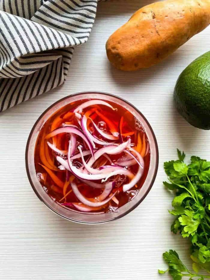 Place the onions in a glass jar and pour in the vinegar mixture. Let cool for 10 to 15 minutes before refrigerating.