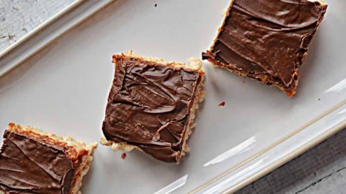 Rice Krispies Treats extra special by adding a delicious layer of dulce de leche on top, followed by a layer of chocolate carefully placed in an off white serving plate