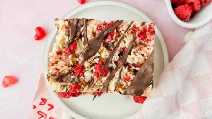 a plate with Rice Krispies Treats with yummy freeze-dried raspberries with real raspberries on the sides