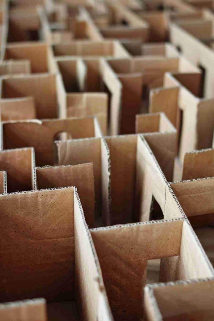 Make a miniature maze by gluing cardboard pieces of different sizes together and cutting out square holes. Kids can help plan the layout and navigate the maze with tiny toys for a fun activity.
