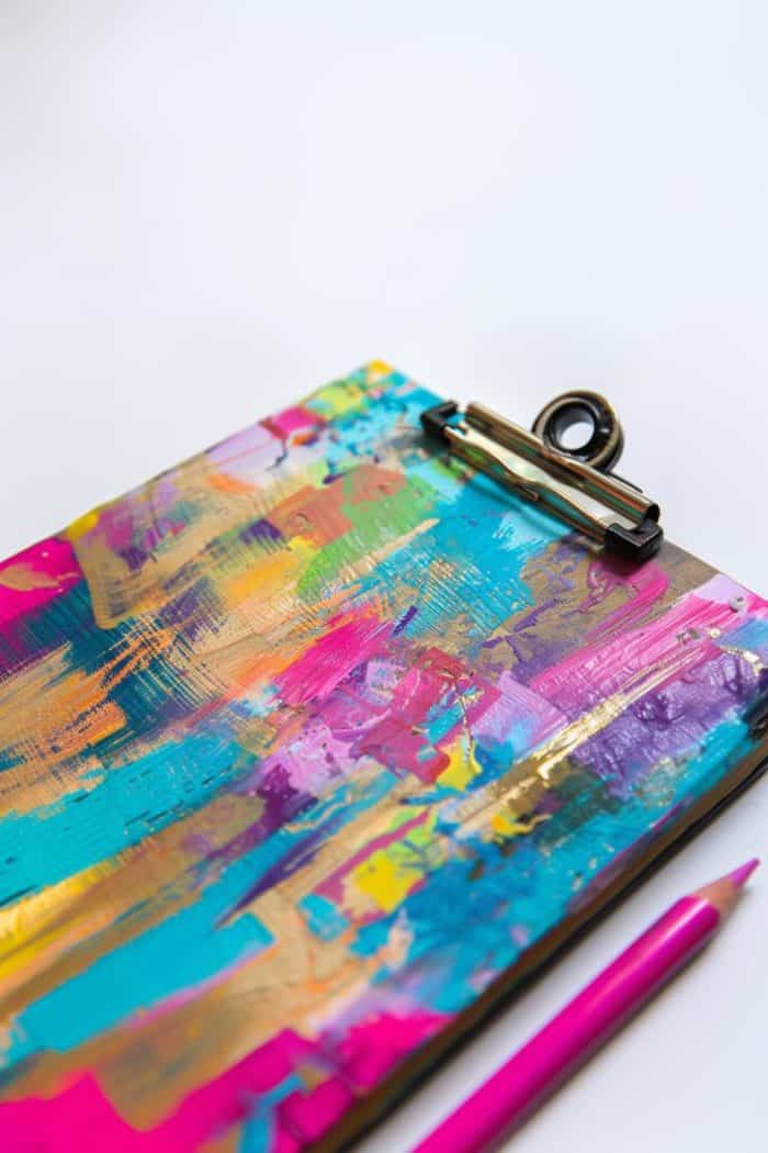 Utilize a brush to create strokes in different colors onto a clipboard, crafting a richly textured look with depth and variety.