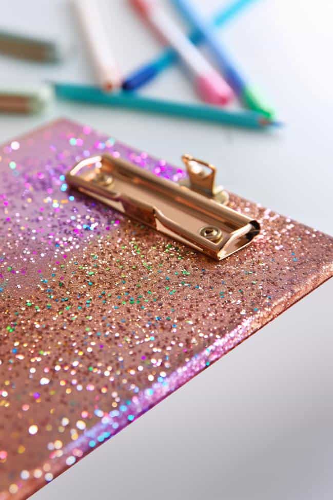 Enhance a standard clipboard with a full coat of glitter, creating an eye-catching accessory that brightens up the workspace.