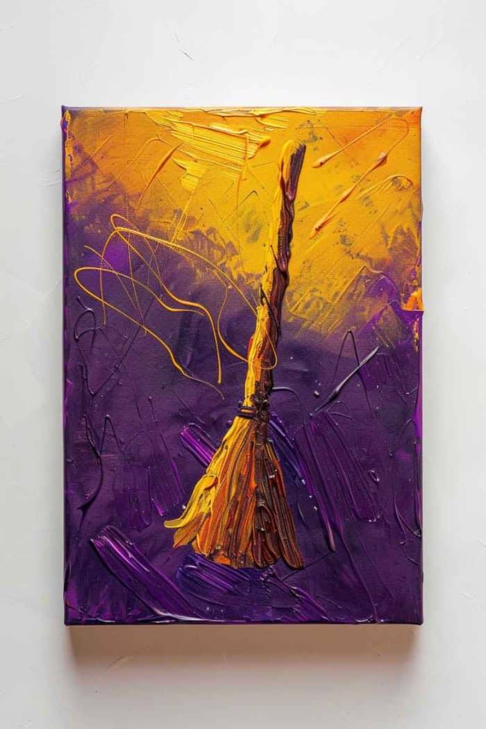 The yellow and brown hues of a witch’s broom stand out against a canvas with a mix of yellow and purple, coming together for an easy-to-make painting that brings witchy whimsy to your Halloween display.