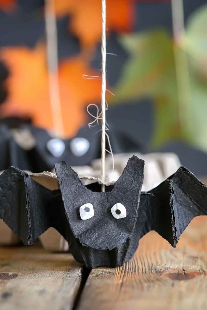 Fashion bats by cutting egg carton sections and painting them a deep black. Add wings made from scrap parts of egg cartons, paint them black to mimic the bat's wing structure, and attach them to the body.
