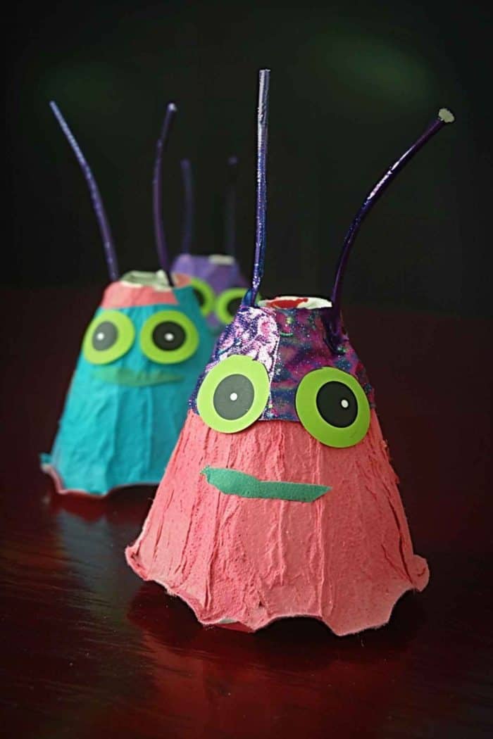 Craft extraterrestrial beings using inverted egg carton cups for the body, painting them in bright colors. 