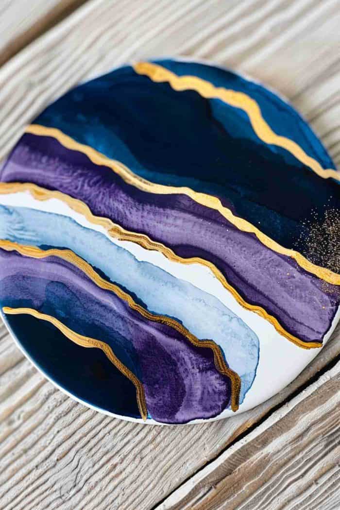 Paint coasters to resemble the vibrant and intricate patterns of geode slices, using gold leaf to accentuate their natural luxury.
