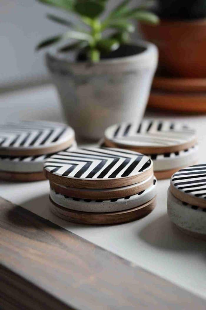 Paint sharp chevron patterns in black and white on wooden coasters for a modern, monochromatic look. This classic design offers visual impact and sophistication, suitable for any contemporary home setting.