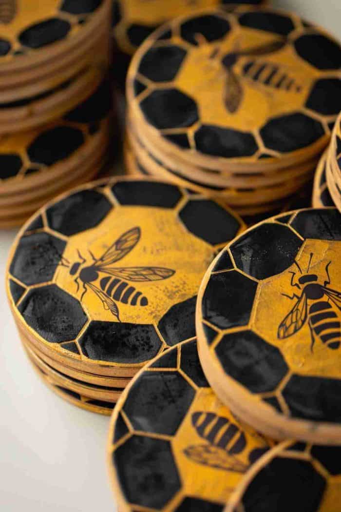 Design coasters with a honeycomb pattern and tiny bee accents, reflecting the exquisite structure of beehives in golden and black hues.