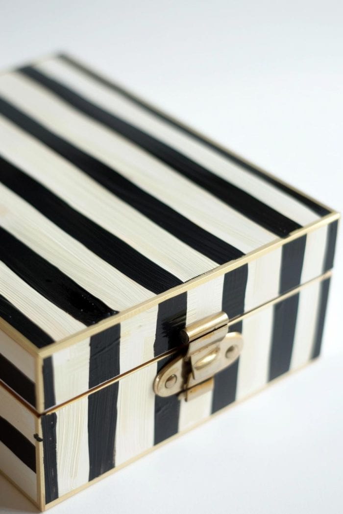 For a white jewelry box with a minimalist aesthetic, apply painter's tape in evenly spaced intervals.