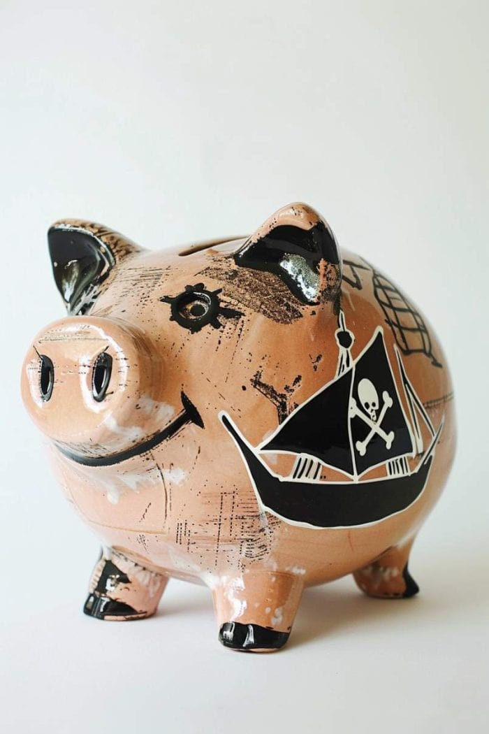 This piggy bank features a pirate ship design with a black flag featuring white crossbones. It’s a thrilling piece where young adventurers can store their loot.