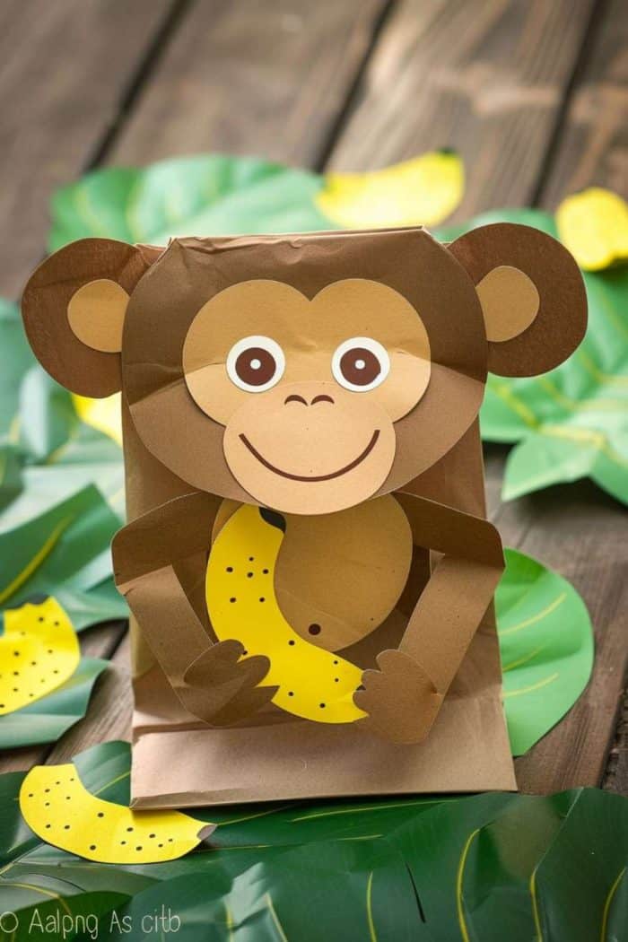 a banana paper cutout in its paws, made through a paper bag