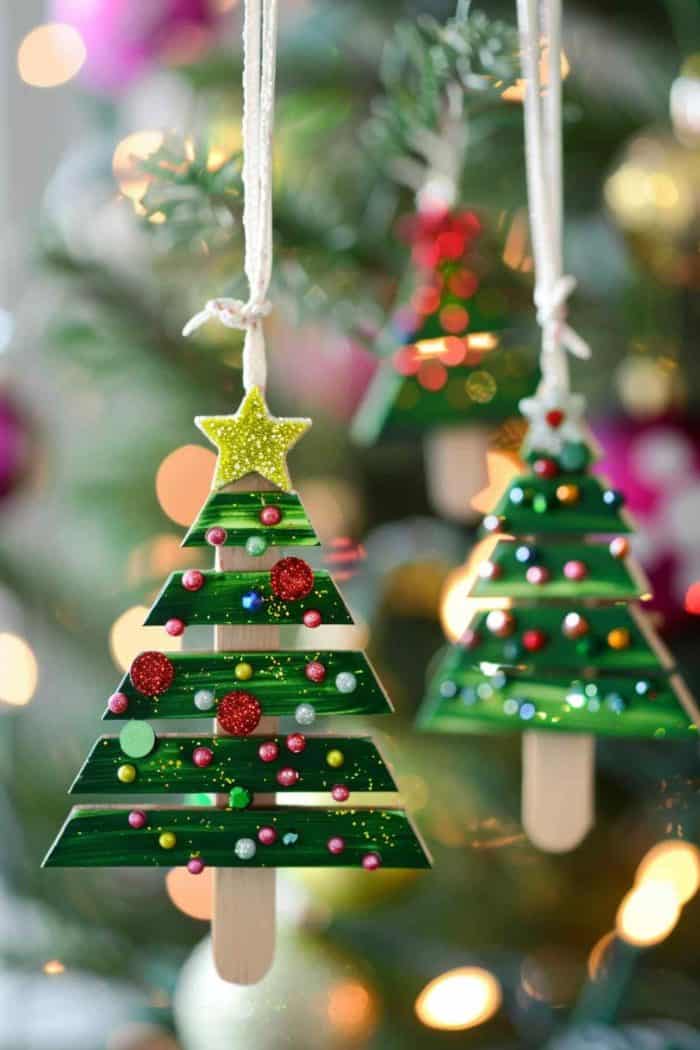 Craft festive Christmas tree ornaments using popsicle sticks. Cut the edges of each stick to form the tree’s triangular shape, then decorate with glitter, beads, and small ornaments. Paint the sticks green and add a star on top for a finishing touch.