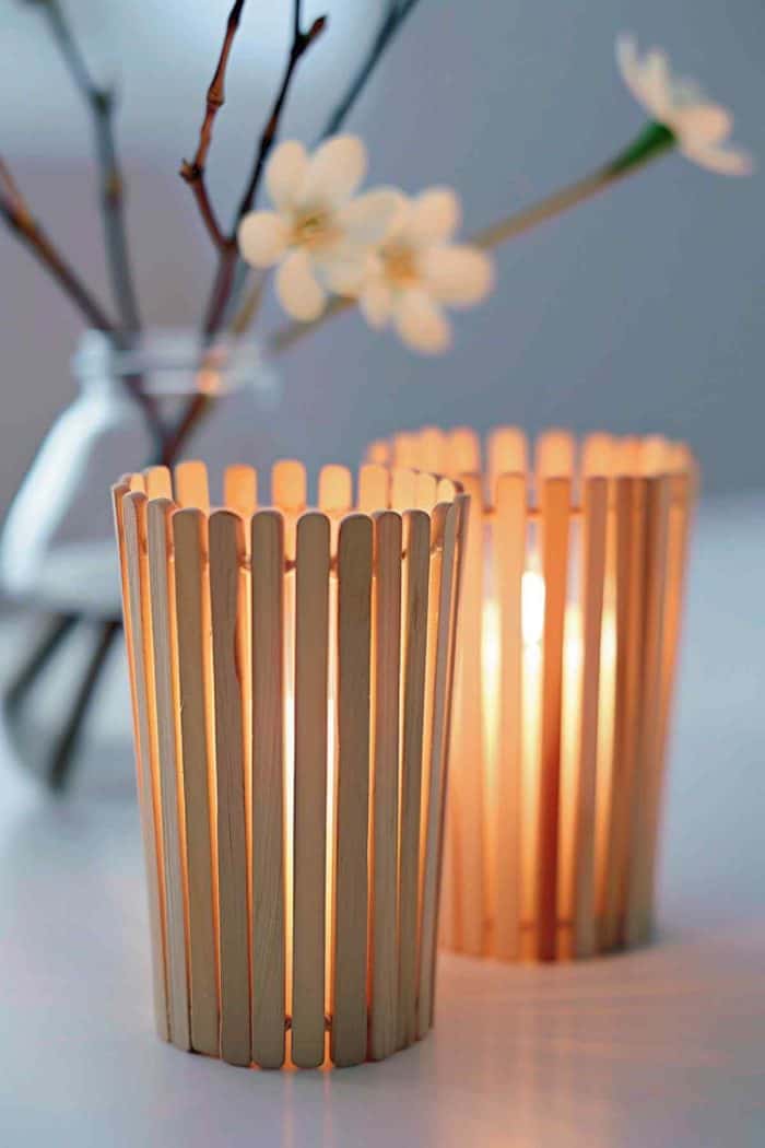 Make candle holders with popsicle sticks that create a warm, glowing ambiance. Glue the sticks vertically around a glass jar or votive holder, leaving small gaps for light to shine through. 