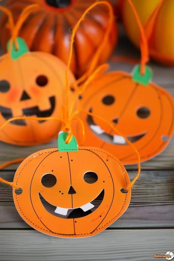 Cut sturdy cards into pumpkin shapes and leave holes for the eyes and face to create fun masks.