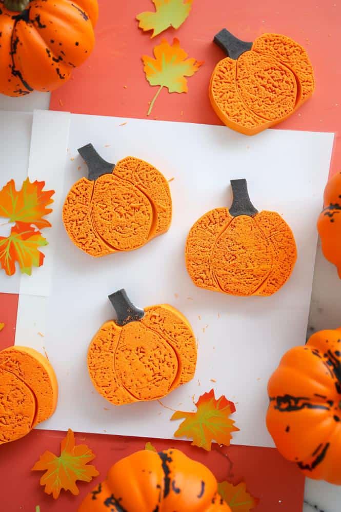 Cut pumpkin shapes from foam sheets and adhere them to blocks or sturdy cardboard to create stamps.