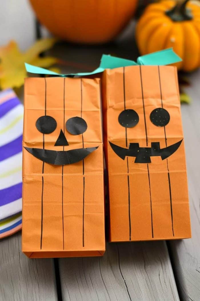 Create paper bag crafts with pumpkin faces by decorating the bottom of the bag with cut-out facial features and a stem.