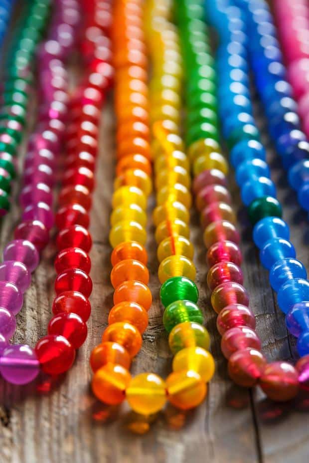 Thread a colorful selection of beads, varying in hue to represent each color of the rainbow, onto a string or elastic cord. 