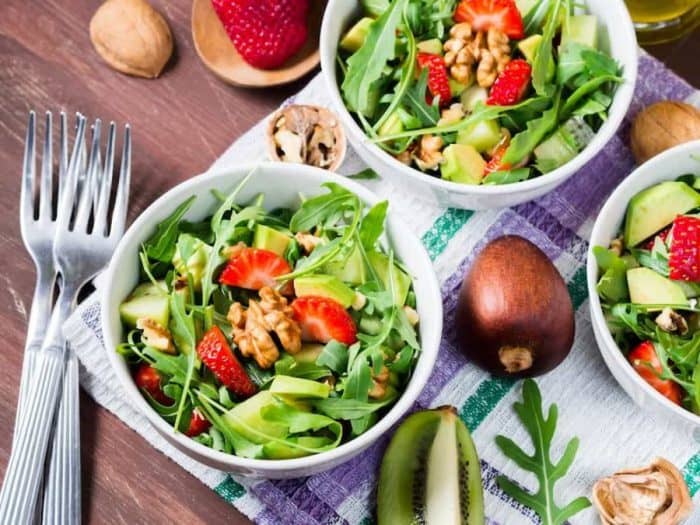 3 bowls of avocado salad with strawberries and walnuts