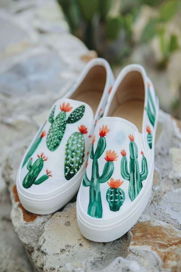Slip-ons feature a variety of cactus shapes, each detailed with tiny blossoms, against a neutral backdrop, creating a desert-inspired ensemble. 