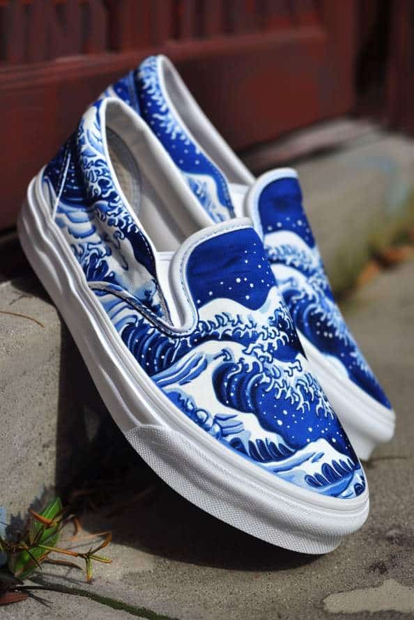 Slip-ons are decorated with the iconic Japanese wave print, featuring stylized blue waves with white crests crashing across the shoe in dynamic patterns. 