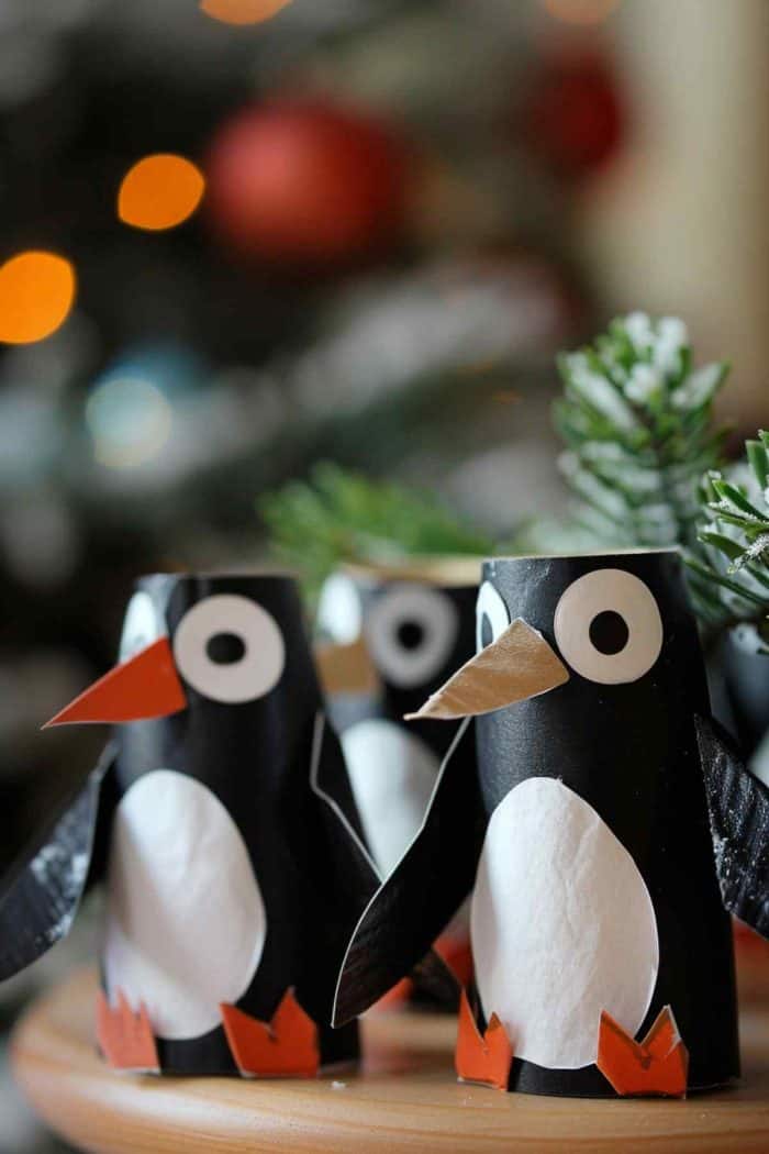 These penguin figurines are crafted from toilet paper rolls, and their bodies are painted in a stark black-and-white pattern. 