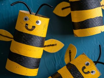 Craft bees by painting alternating black and yellow stripes around toilet paper rolls. Cut wings from wax paper or cardstock and attach them to the back.