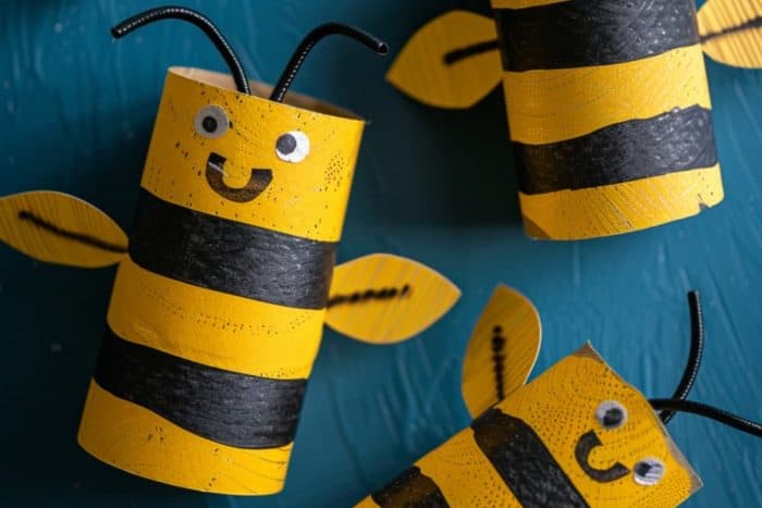 Craft bees by painting alternating black and yellow stripes around toilet paper rolls. Cut wings from wax paper or cardstock and attach them to the back.