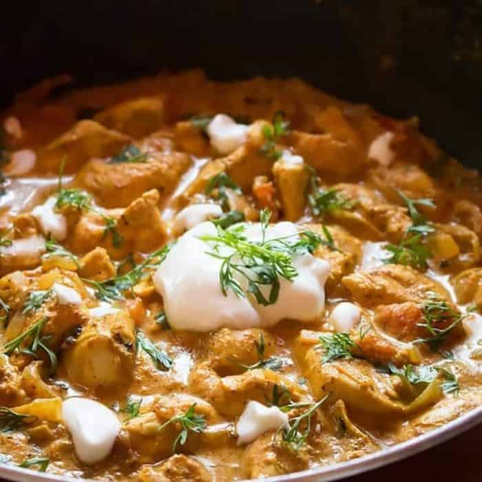 This one-pan chicken balti boasts chicken pieces in a robust sauce thickened by onions, tomatoes, and cream.