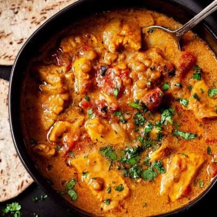 Simply prep your chicken by sautéeing it in your Instant Pot with onions, garlic, kosher salt, ginger, and curry powder, add fire-roasted tomatoes, coconut leaves, and bay leaves, then leave to cook. 