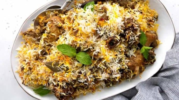 Layers of long-grain basmati rice, spiced chicken and lamb, and fried onions are masterfully assembled to make this biryani dish.