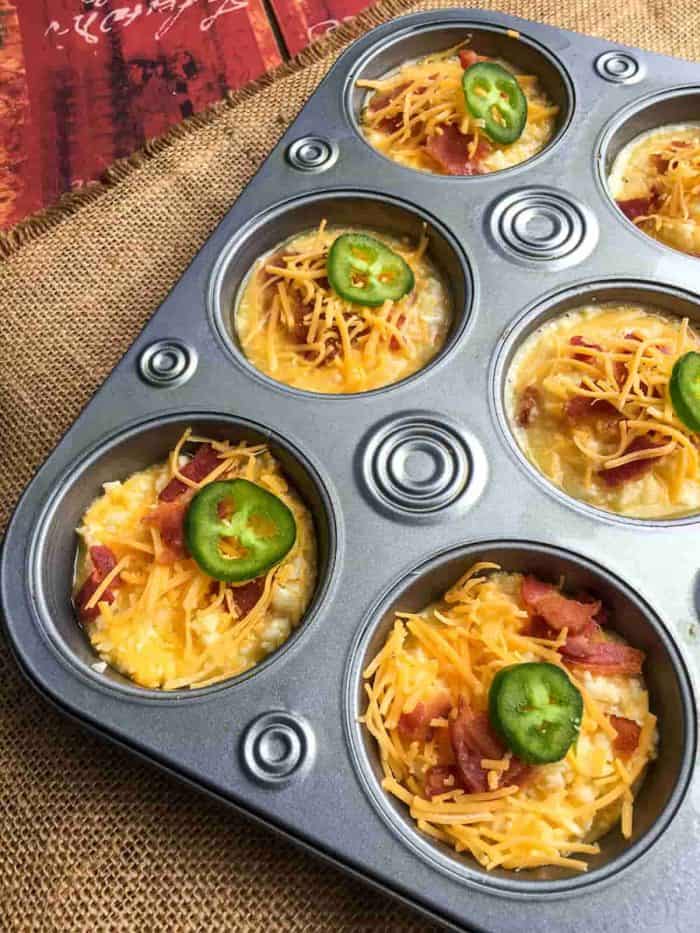 Fill the muffin tin with your cauliflower batter and top each with the remaining bacon, shredded cheese, and one jalapeno ring. 