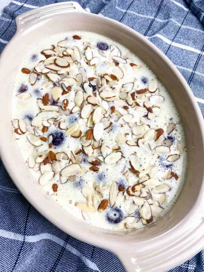 Arrange the cherries in the baking dish you greased earlier. Pour the batter over them and sprinkle with slivered almonds. 