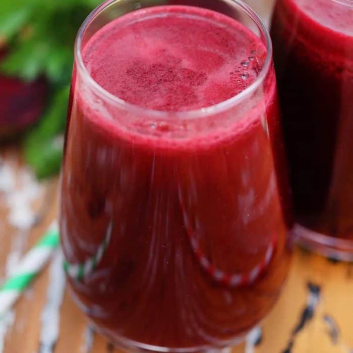 a glass of detox beet juice placed on a wooden table