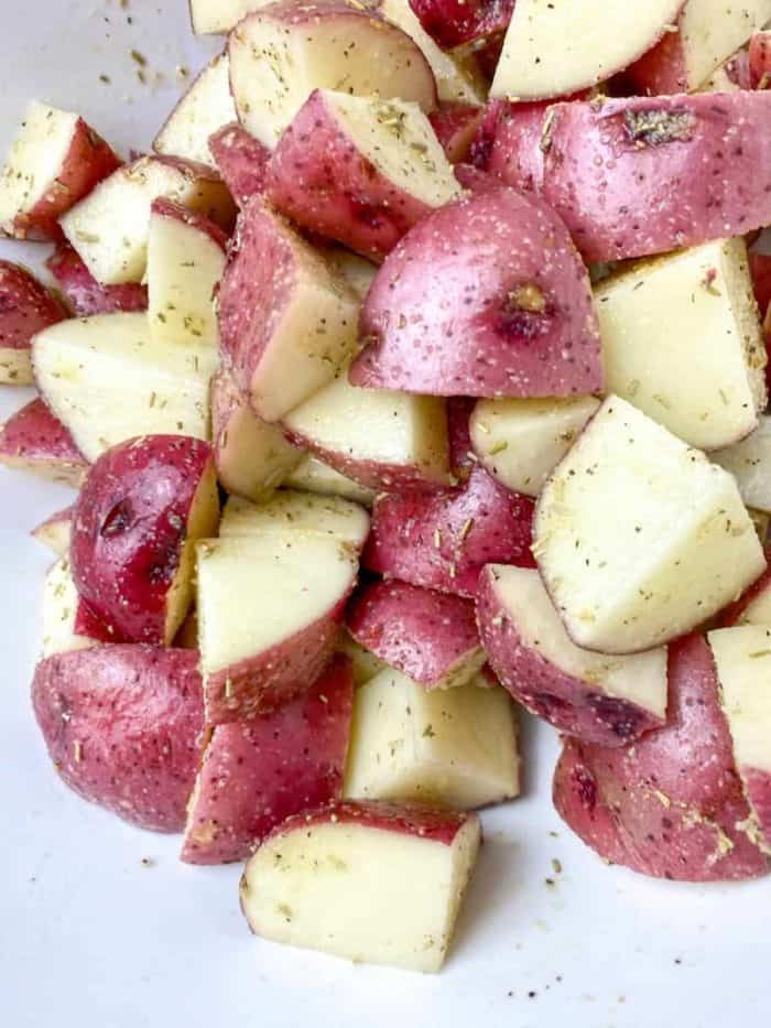 diced potatoes into a bowl and add the remaining olive oil and the same herbs and spices