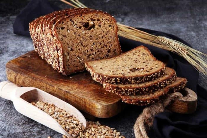 Sliced rye bread on cutting board. Whole grain rye bread with seeds