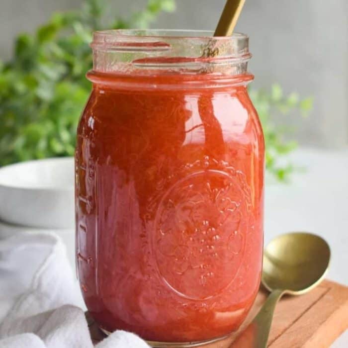 this rhubarb sauce in a jar with gold spoon beside it