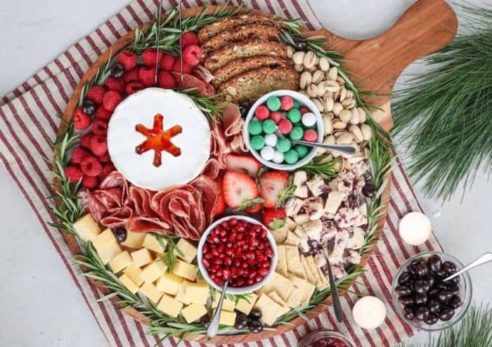 Enjoy this merry medley of holiday favorites, with Italian cold cuts, red-colored fruits like strawberries and raspberries, bread, and crackers.