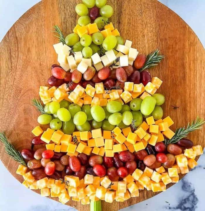 christmas fruit charcuterie board It features only red and green grapes and various cheeses, which are arranged to mimic the look of a Christmas tree.