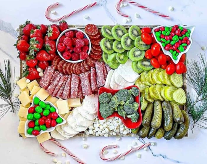 Both fun and healthy, this Christmas charcuterie board idea features meats, fruits, veggies, cheese, and candies in classic Christmas hues: red, green, and white!