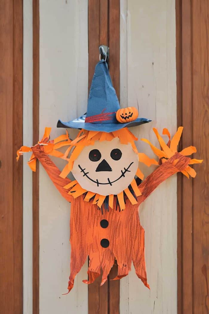 Welcome guests to your Halloween gathering with cheerful scarecrow door hangers crafted from construction paper! 
