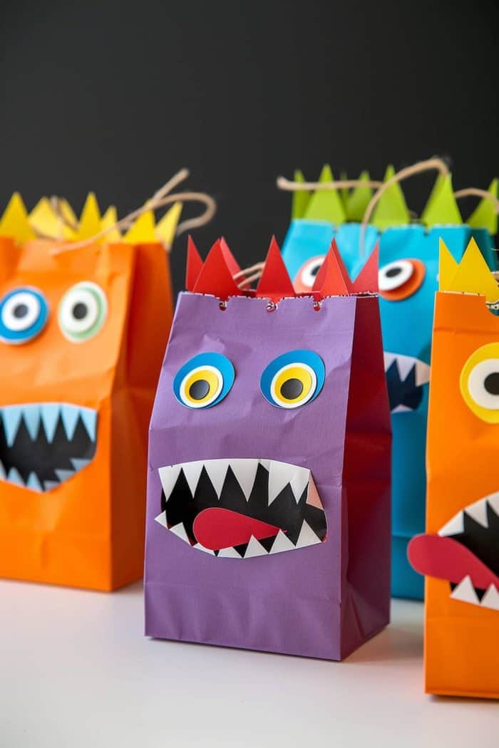 Let your little ones help out with party prep by adding cutouts of monsters’ facial features from construction paper to their treat bags! 