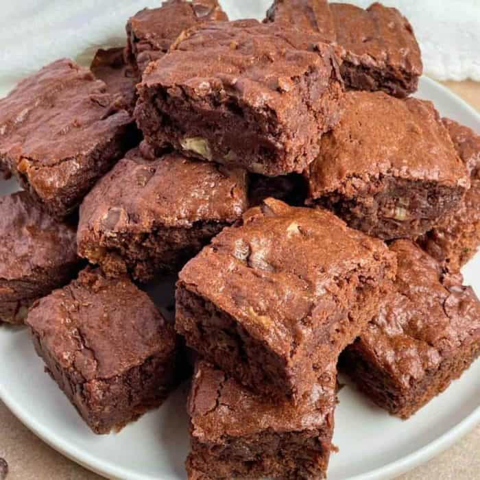 Ripe bananas lend their natural sweetness to these vegan banana brownies, creating a dense, fudgy base infused with a delightful chocolate flavor and punctuated with chopped nuts.