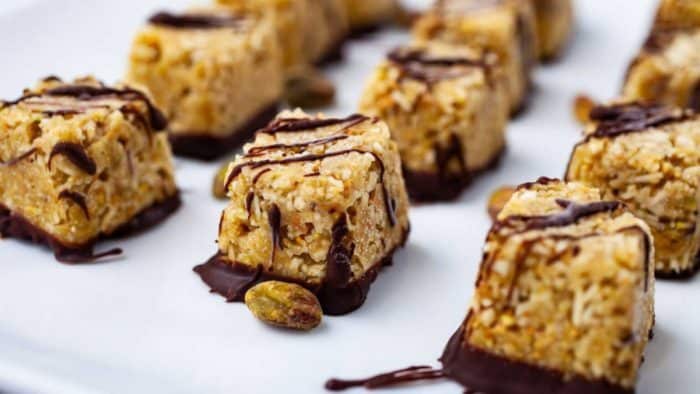 Enjoy the blend of textures and flavors in these bites, which feature coconut shreds and roasted pistachios pulsed together, then dipped into and drizzled with luscious dark chocolate.