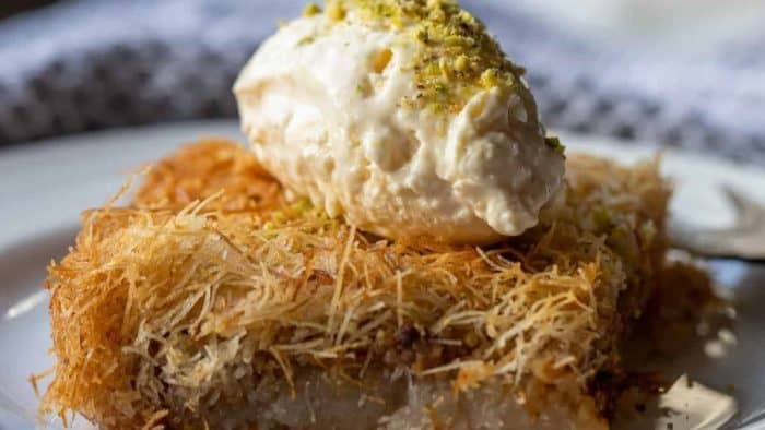 Kadaif, a traditional Turkish dessert, weaves delicate, thread-like kadaif pastry dough into a crunchy nest, layering it with a walnut filling and soaking it in sweet syrup.