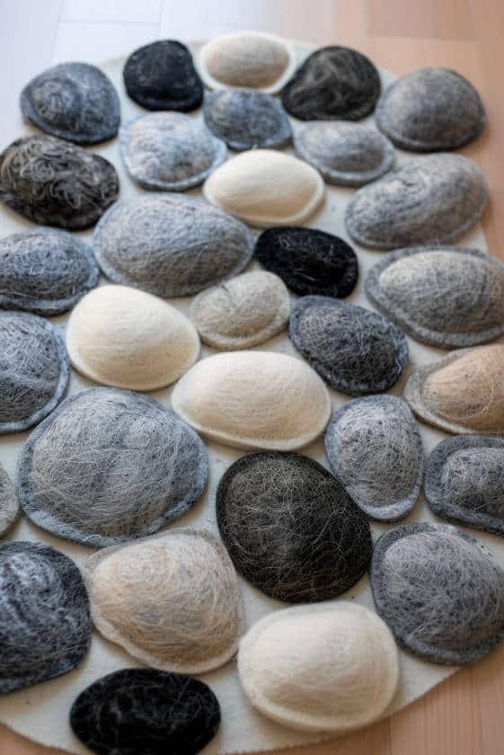 Make a felt wool pebble rug by clustering circles of felt in various shades of gray and earth tones, giving the illusion of real pebbles. 