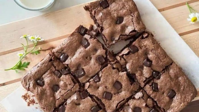 sourdough discard to produce moist, fudgy brownies with a shiny crust on a parchment paper and cooling rack
